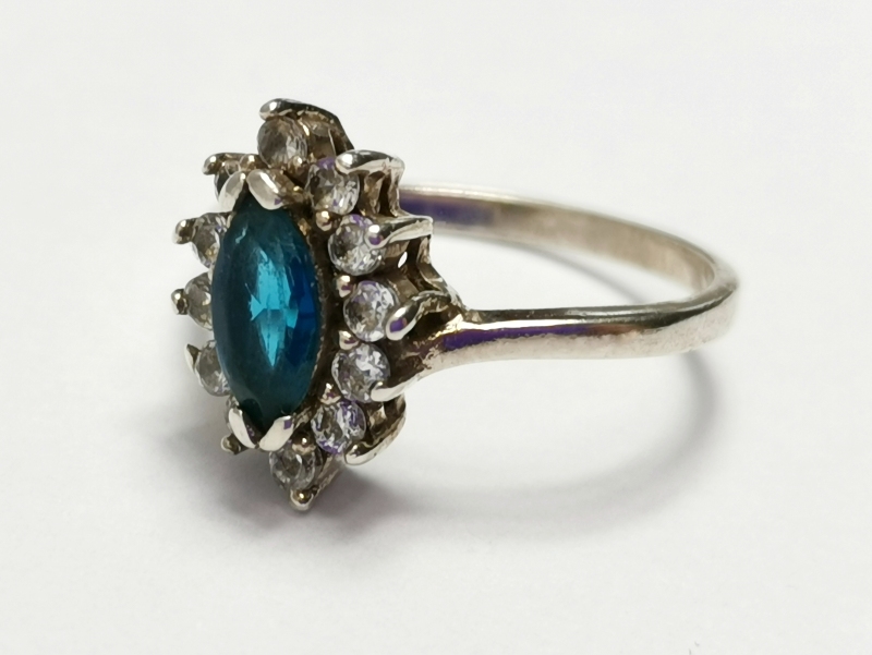 Stříbrný prsten s modrým kamenem a se zirkony